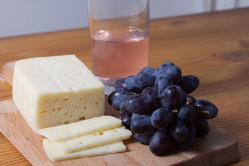cheese and grapes on the wooden table