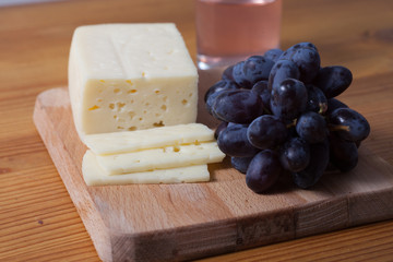 cheese and grapes on the wooden table