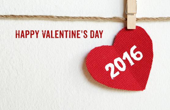 Happy valentine's day and red fabric heart shape hanging on cloth line background with copy space