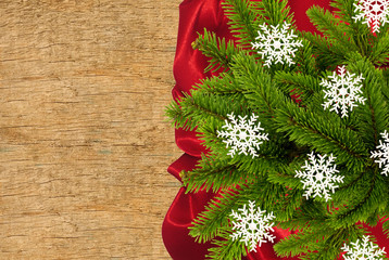 Red cloth with fir tree branch over wooden texture close-up