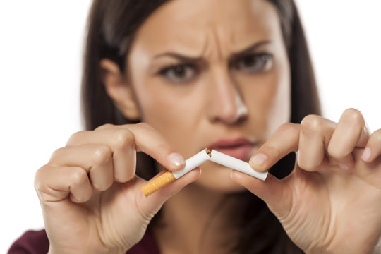 angry young woman breaking a cigarette