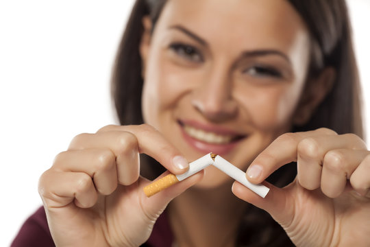 happy young woman breaking a cigarette