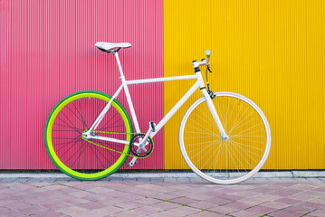 Fototapeta City bicycle fixed gear on yellow and red wall. obraz