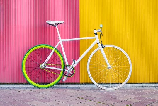 City bicycle fixed gear on yellow and red wall.