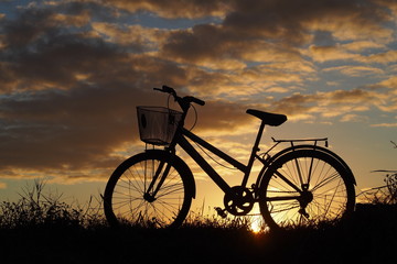 Fototapeta na wymiar A bicycle on country road in the evening: silhouette photo