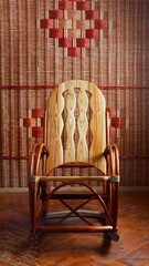 rocking chair made of wood on the wall background wicker, front view