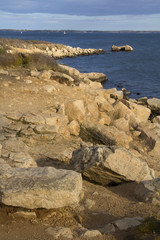 Fototapeta na wymiar Curving shoreline with boulders and gravel along the Connecticut coast on Long Island Sound.