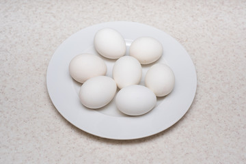 Boiled or raw eggs on the white plate