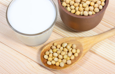 Glass of soy milk on a wooden background.