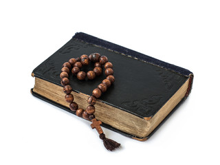 Rosary on the Bible isolated on a white background. Holy book.