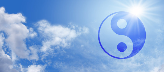 Symbolic Yin Yang on Blue Sky Banner -  Wide blue sky panorama with fluffy clouds and a bright sunburst behind a semi-transparent blue Yin Yang Symbol