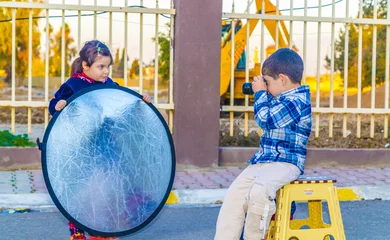 Small boy using vintage camera and small girl holding silver reflector  © bilalizaddin