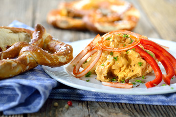 Bayerische Käsespezialität - Portion Obazter mit Zwiebelringen und Brezel