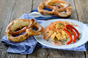 Bayerische Käsespezialität - Portion Obazter mit Zwiebelringen und Brezel