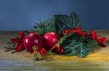 traditional christmas composition with two apples, ivy leaves and small red bows
