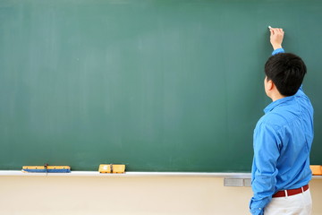 教室の黒板の前で授業をする教師