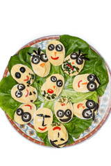 Deviled eggs looking like human faces on a plate