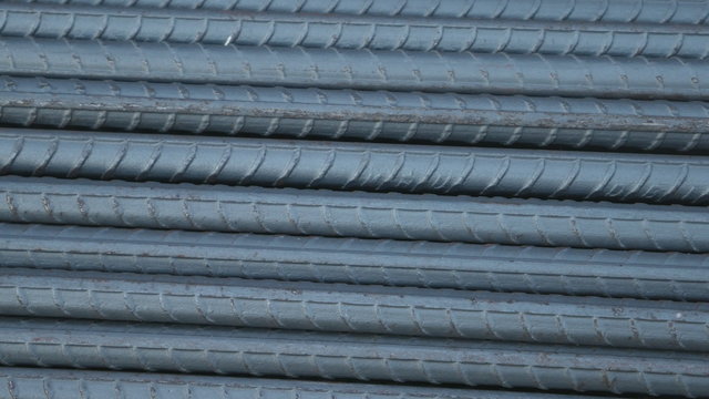 Panning shot of Steel rods or bars used to reinforce concrete for construction
