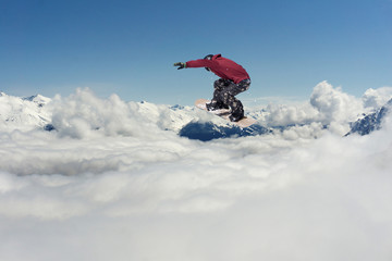 Naklejka na ściany i meble Flying snowboarder on mountains. Extreme sport.