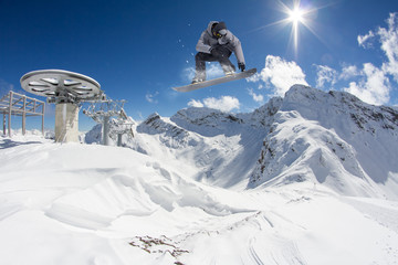 Flying snowboarder on mountains. Extreme sport.