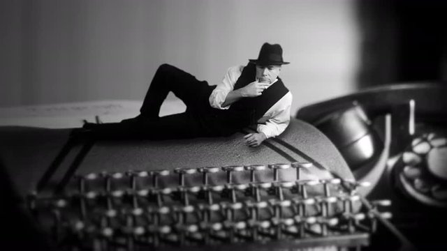 tiny film noir man laying on a vintage typewriter thinking