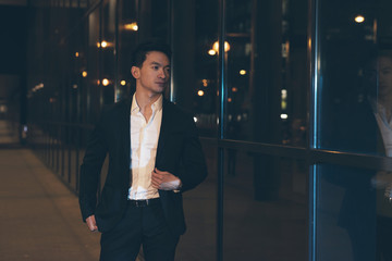 Fototapeta premium Asian businessman in city at night.