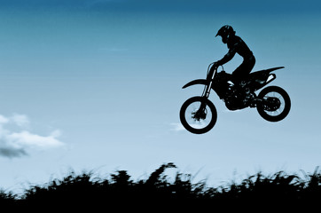 Fototapeta na wymiar motocross action with sunset background