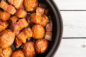 Vietnamese caramelized pork belly with deep fried eggs  in clay