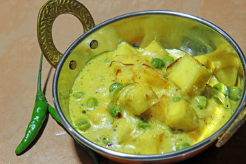 Paneer cheese and green peas cooked in a Creamy sauce, an Indian curry goes well with chapati and rice with copy space.