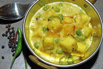 Paneer cheese and green peas cooked in a Creamy sauce, an Indian curry goes well with chapati and rice with copy space.