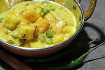 Paneer cheese and green peas cooked in a Creamy sauce, an Indian curry goes well with chapati and rice with copy space.