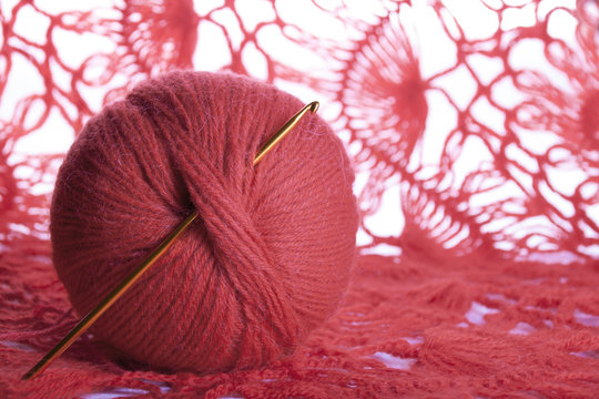 The tangle of thread and knitting hook against the background of