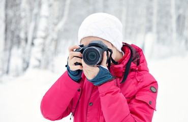 Fototapeta na wymiar girl with the camera on the background of winter snow