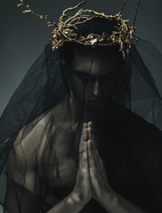Portrait of a masculine handsome man in elegant black cloth, with gold crown - 99083879