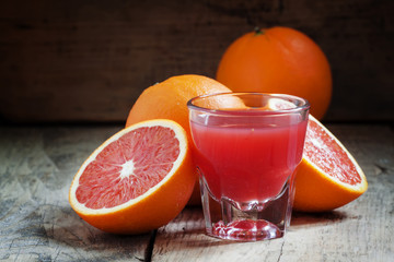 Juice of red Sicilian oranges in a large glass, selective focus