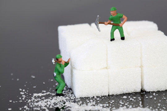 Miniature builders sugar cubes / miniature scale model builders breaking up sugar cubes.