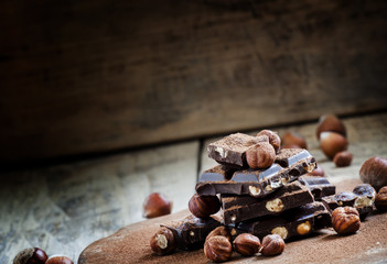 Dark chocolate with hazelnuts on an old wooden background, selec