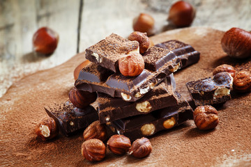 Dark chocolate with hazelnuts on an old wooden background, selec