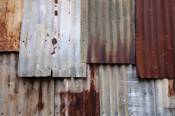 Rusted corrugated zinc sheets overlapping to form a fence