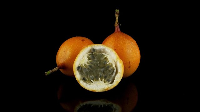 Passion fruit maracuja granadilla on black background.