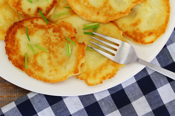 Delicious potato fritters on white plate, closeup
