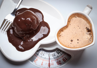 Coffee and chocolate cake on weighing scale.