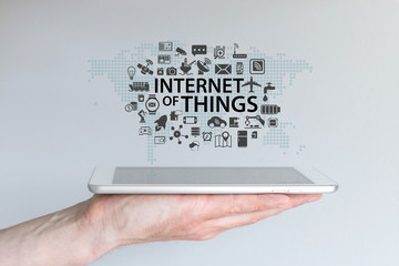 Hand holding tablet or modern smart phone. Internet of things (IOT) background concept.
