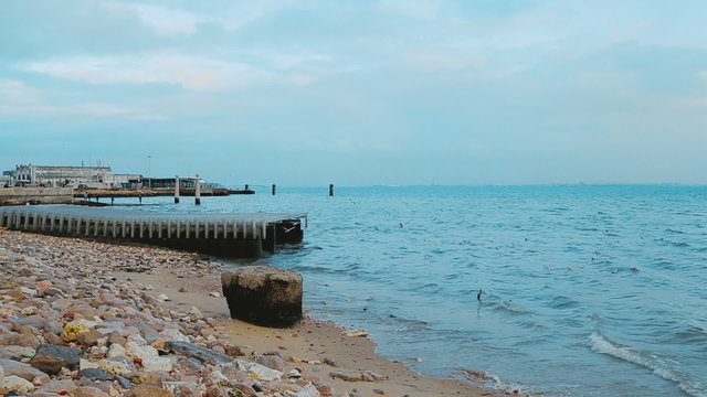 An opening shot of the riverside in Lisbon, Portugal by dusk. Seagulls can be seen flying around.
