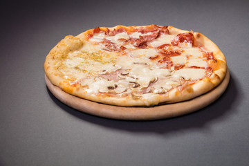 Quattro Stagioni pizza with mozzarela, ham, bacon, mushrooms...