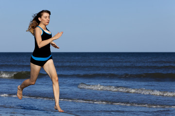 Woman running on the beach barefooted