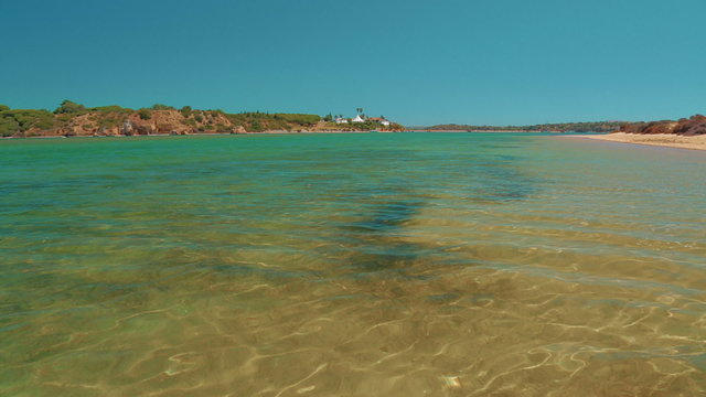 A wide inspirational shot showing the pristine turquoise waters of the Algarve coast in Portugal
