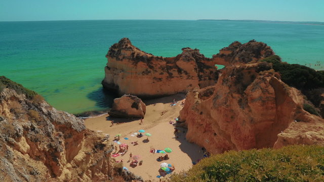 A panoramic top-down view of a rocky beach with tourists in the Algarve, Portugal
