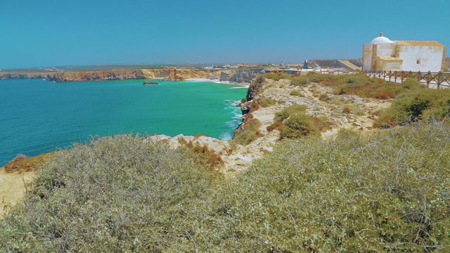 Wide angle shot of the pristine turquoise waters of the Cape of Sagres in Portugal
