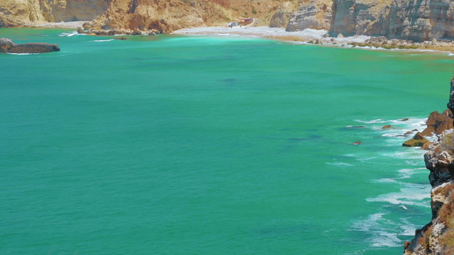 Telephoto shot of the pristine turquoise waters of the Cape of Sagres in Portugal
